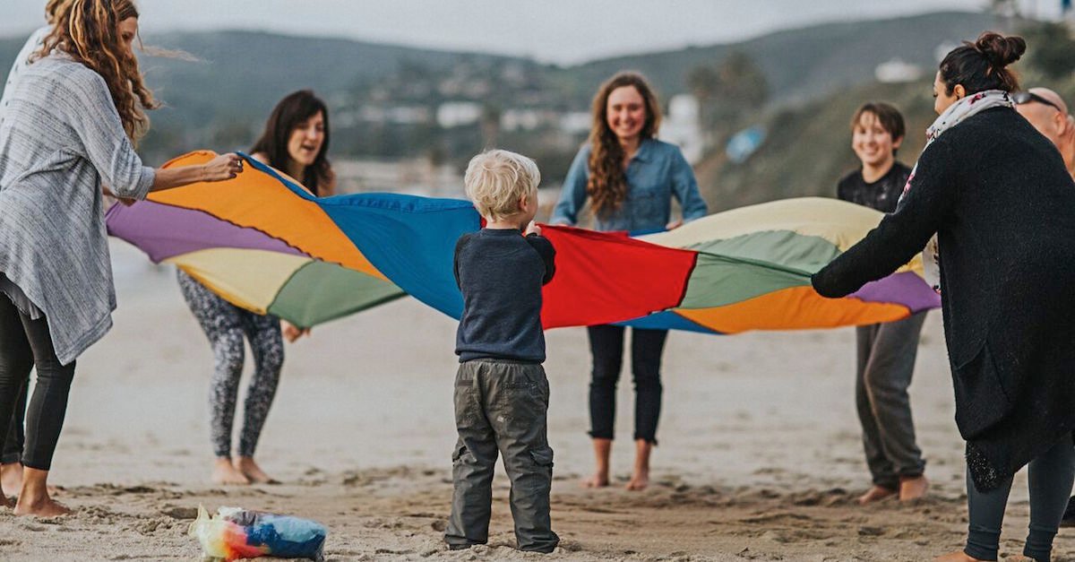 Trainees and Child Playing with a Parachute on the Beach